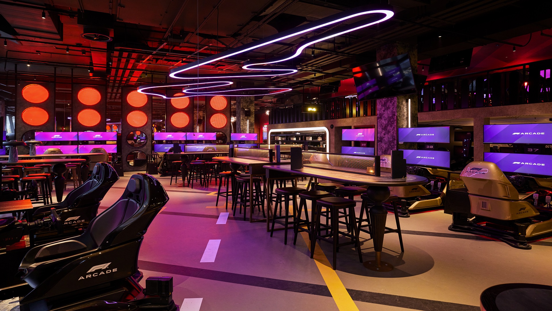 London's F1 Arcade features full-motion racing simulators, delicious food and a fully stocked bar. Image courtesy of F1 Arcade. high-tech activity bar with racing simulator chairs, tables and chairs to relaxing and vibrant mood lighting