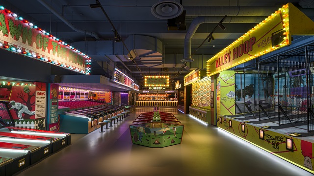 Old school arcade games in a large indoor venue, including basketball and whack-a-mole