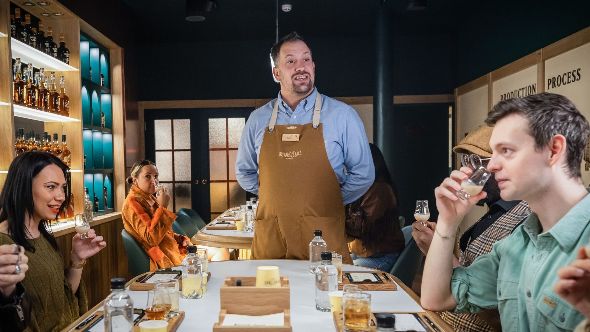 People sit at a white table sampling whisky at the Buffalo Trace Distillery in London