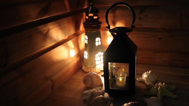 A black lantern sits next to a lighthouse figure with lights.