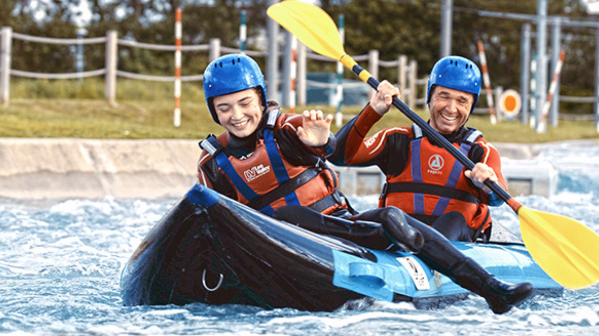 A woman and a man are kayaking along the river at Lee Valley Water Centre