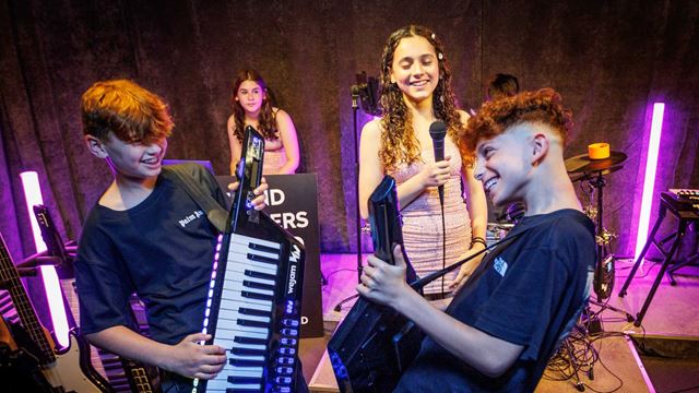 Young musicians play keyboards, sing and perform together during an interactive band session at WeJam. Image courtesy of WeJam.