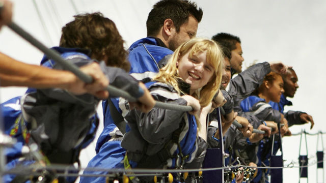 A photo of a young girl looking at the camera, smiling, while enjoying the Up at The O2 walkway.