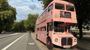 exterior shot of an old Routemaster double decker bus in bright pink with afternoon tea branding embossed on the sides