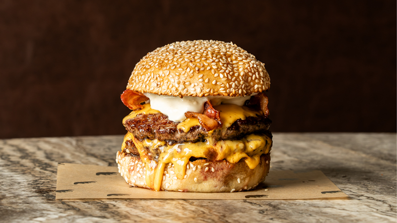 Devour the double black and blue burger at Black Bear Burger, featuring dry aged beef, cheese, smoked bacon, blue cheese sauce and onions. Credit: Black Bear Burger. Image courtesy of Black Bear Burger. The double black and blue burger with dry aged beef, cheese, smoked bacon, blue cheese sauce and onions