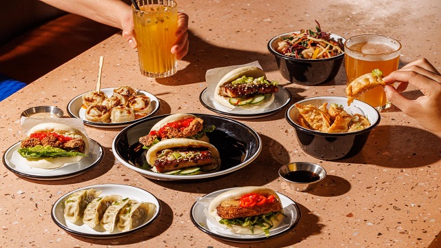 Birdseye view shot of Asian small plates including gyozas and bao buns.