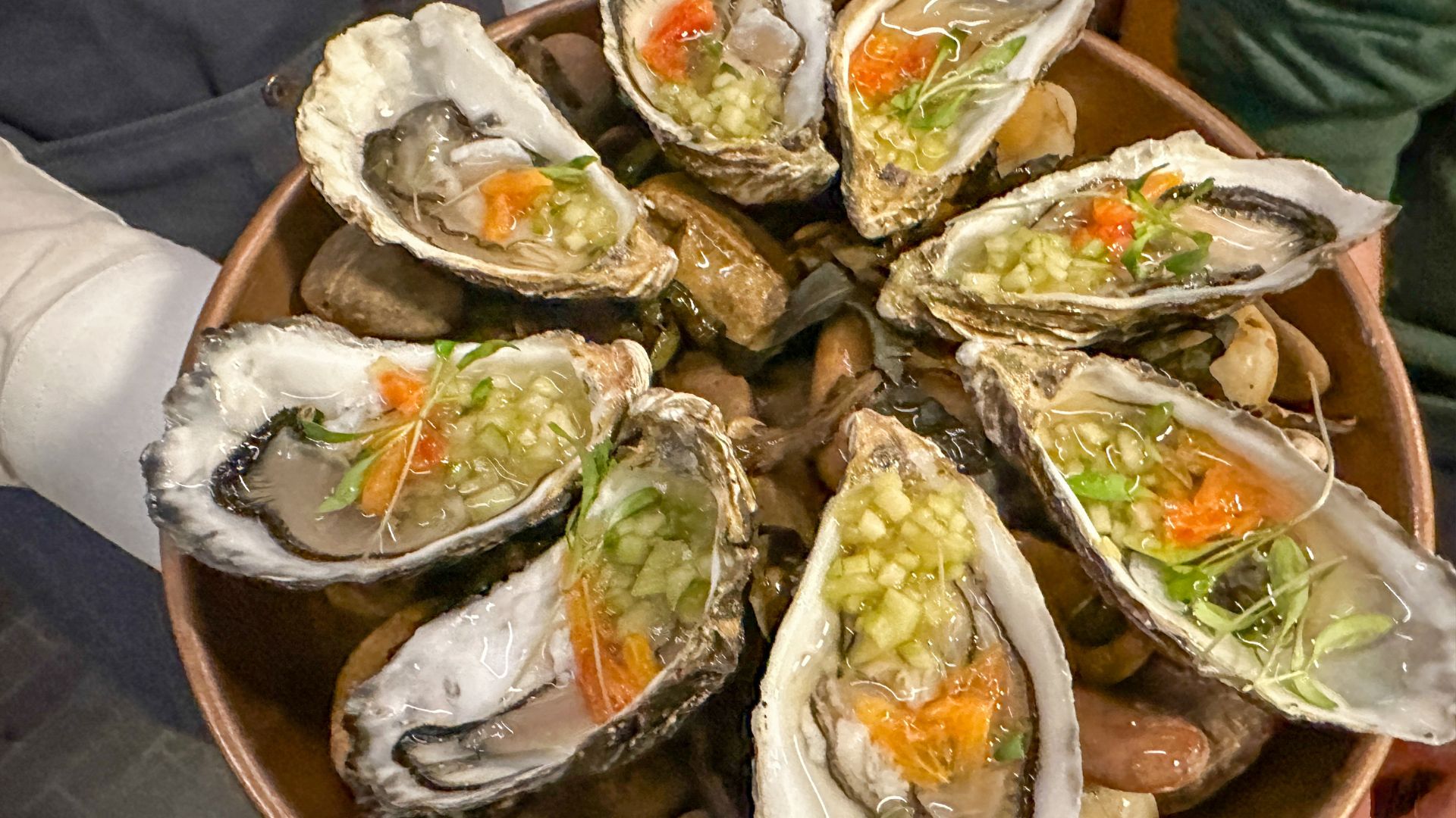 A bowl of freshly shucked oysters topped with finely chopped garnishes at the Guinness Open Gate Brewery London.
