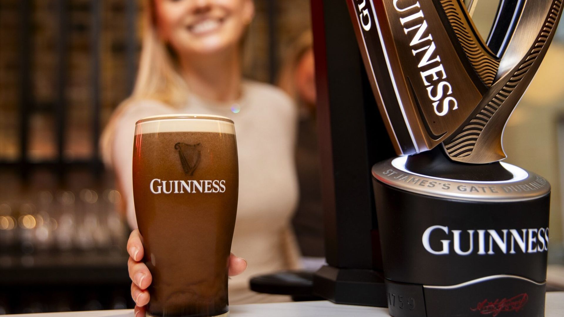 Close-up of a pint of Guinness beside a branded Guinness tap at the London Open Gate Brewery.