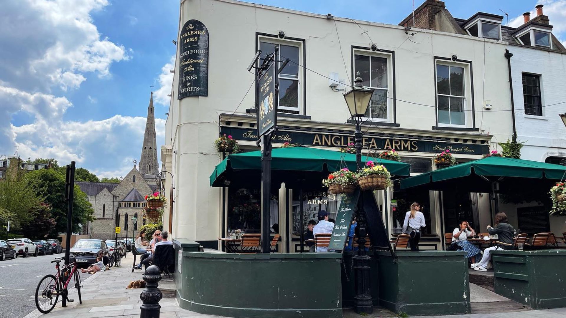 Anglesea Pub exterior on a clear sunny day with church in the background.