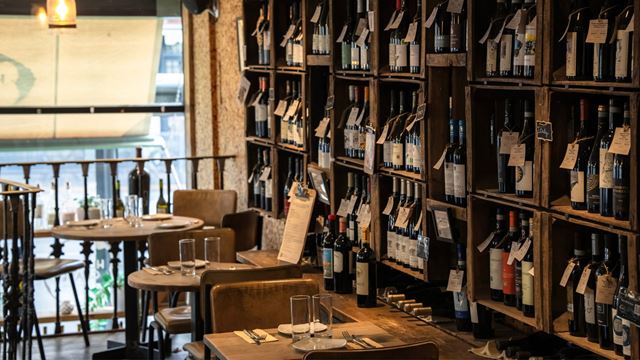 Interior of Humble Grape wine bar with walls stacked with labeled wine bottles.