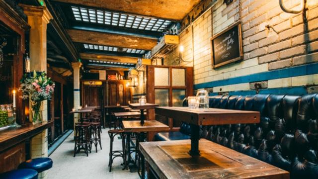 A wine bar with high tables and leisure benches. 