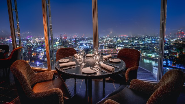 A table by the window of Aqua Shard with a view of London at night