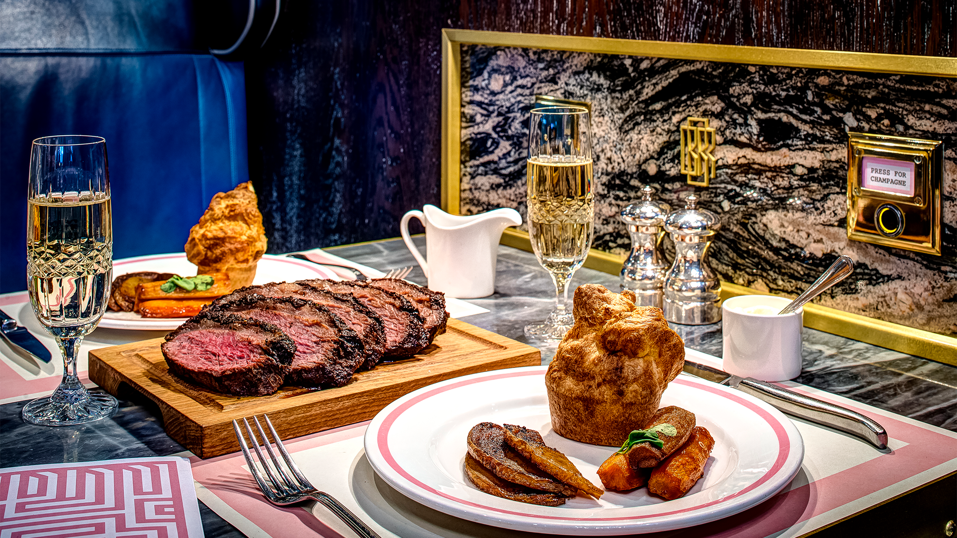 Sunday roast dishes accompanied by glasses of champagne at Bob Bob Ricard