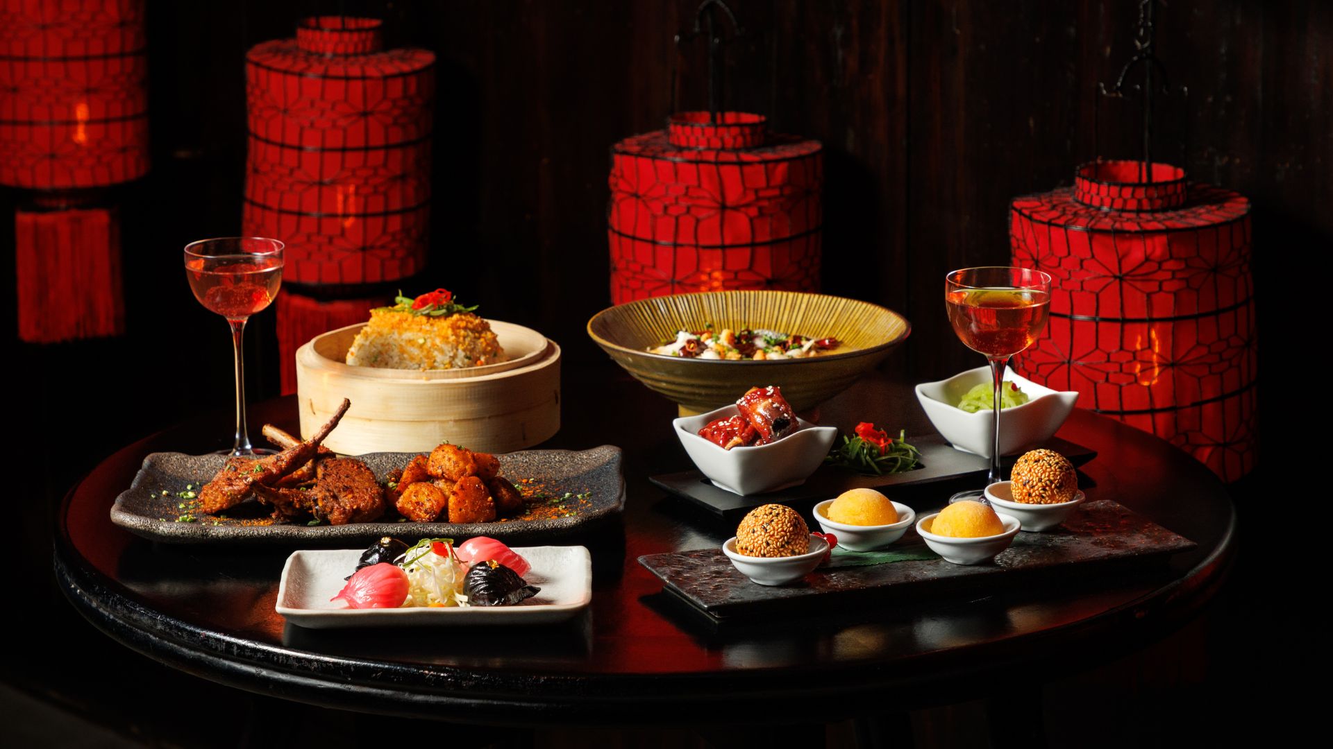 A table covered in chinese dishes on plates and dumpling bowls.