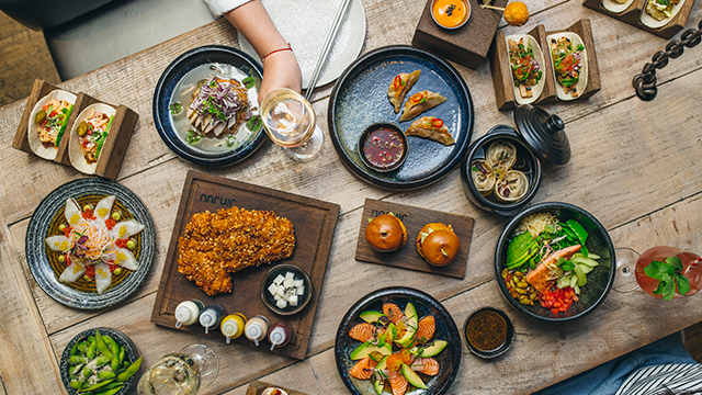 Multiple plates of food, on a table, take from above.