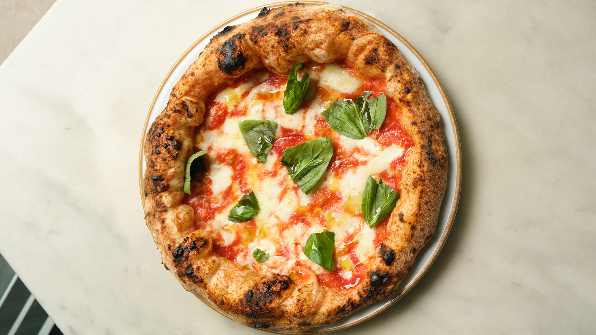 A margherita pizza with basil leaves on top