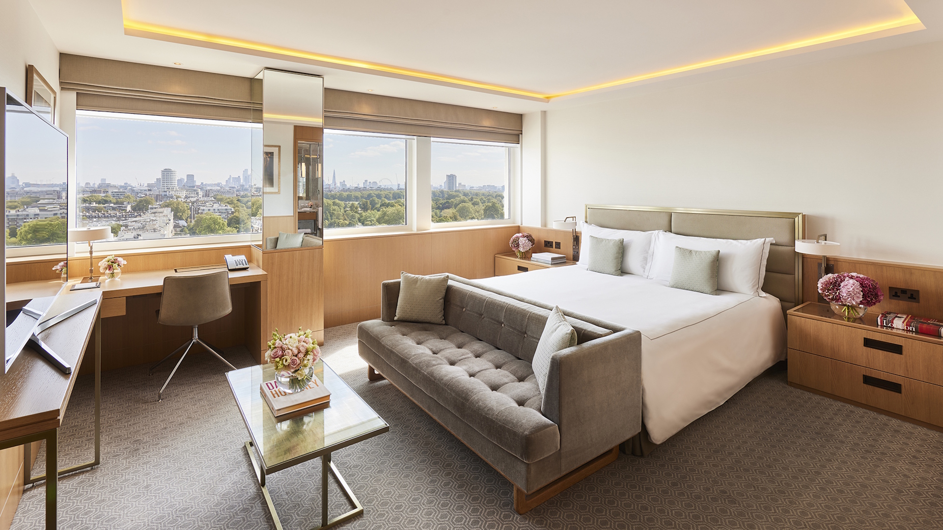 Elegant hotel room decorated in neutral colours, overlooking Hyde Park in London.
