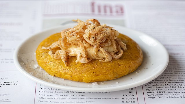 a small white plate with a tortilla topped with shrimps