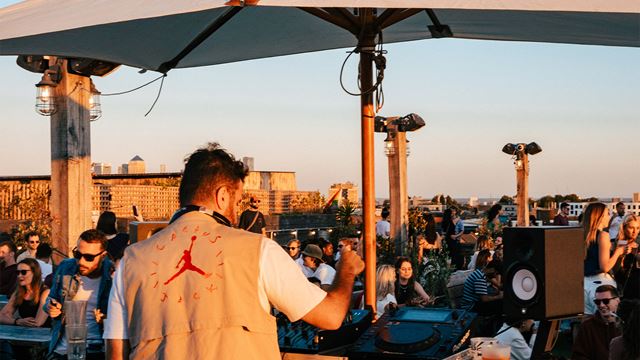 A DJ infront of a crowd at the Netil360 rooftop bar.