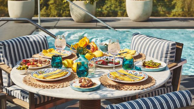 During their Capri in the City takeover, a table is laid out by the pool at the Berkeley Rooftop, featuring a selection of colourful dishes.