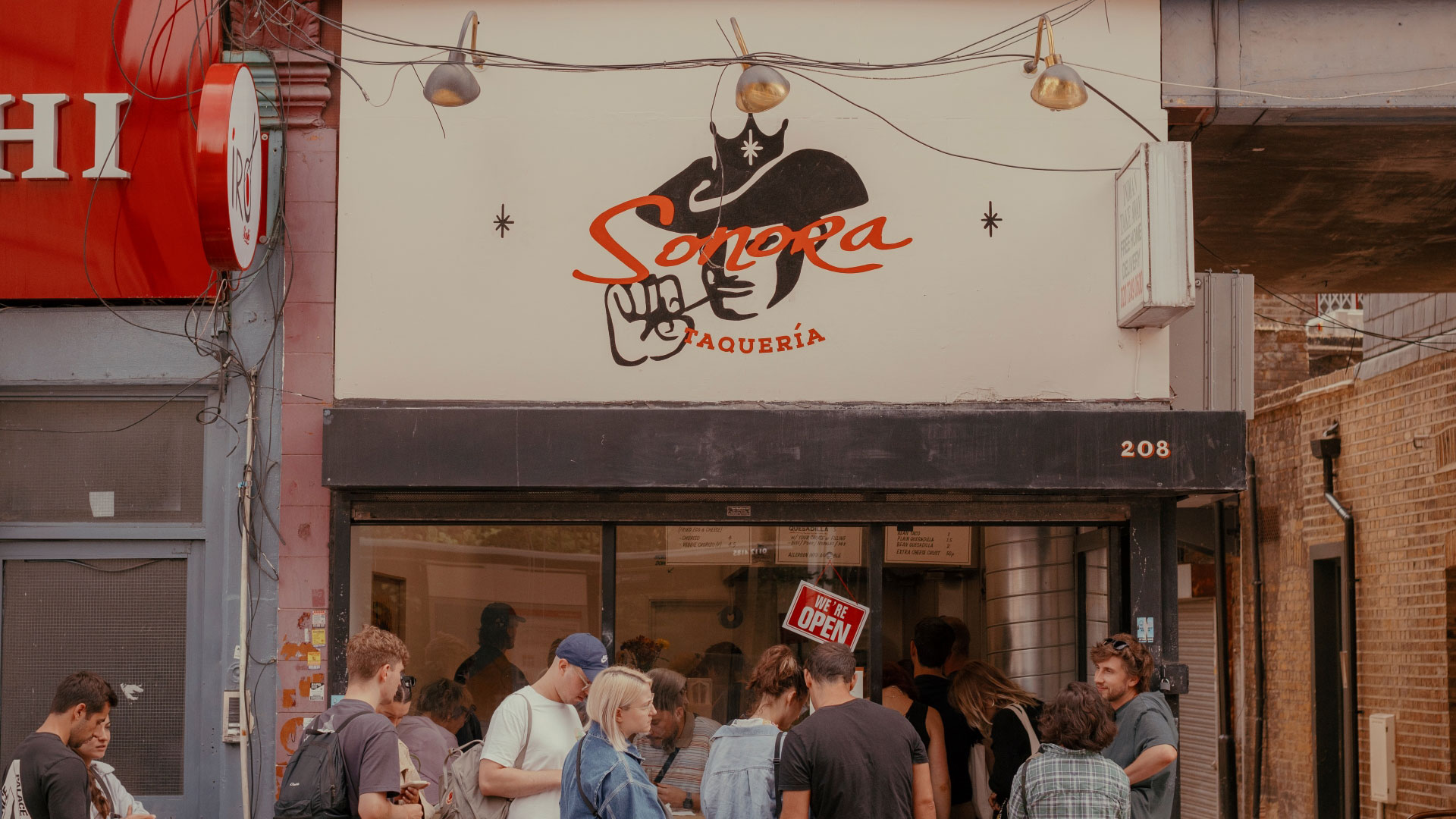 A photo of the exterior of Sonora Taqueria in Stoke Newington with a queue of people outside