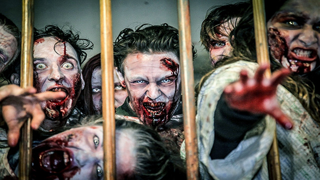 Eine Gruppe von Zombies in einer Londoner immersiven Erlebniswelt versucht, die Besucher durch die Gitterstäbe zu greifen.