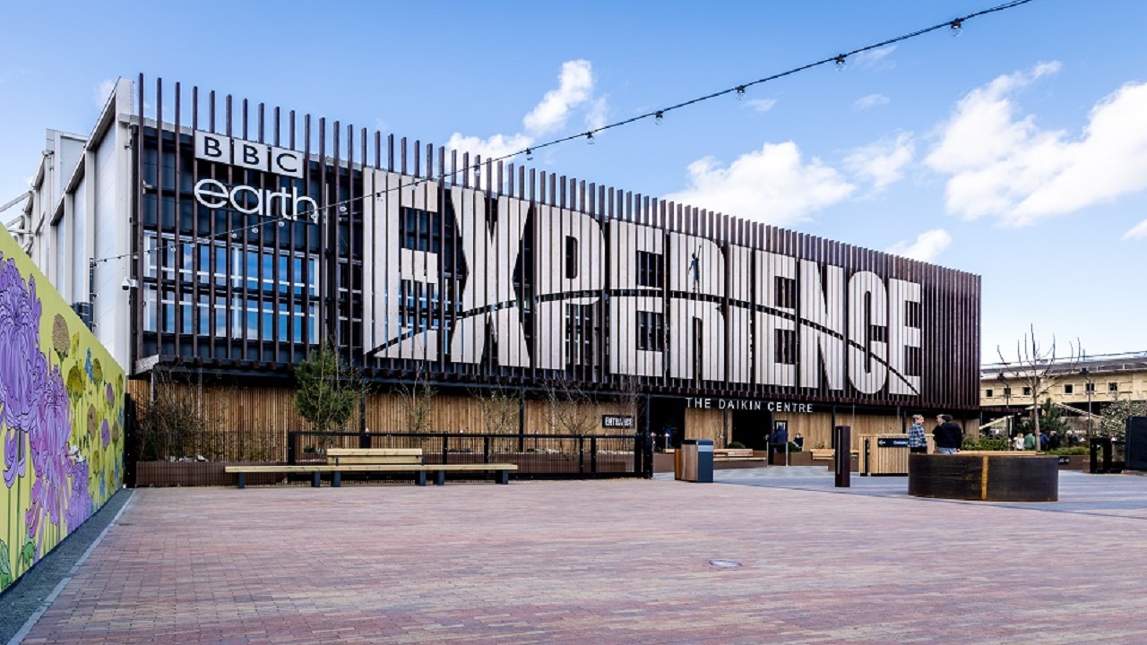 La BBc Earth Experience prend place au Dakin Centre sur Londres. ©BBC Earth Experience Site construit spécialement en bois et en métal pour la BBC Earth Experience, avec un ciel bleu nuageux au l'arrière-plan.