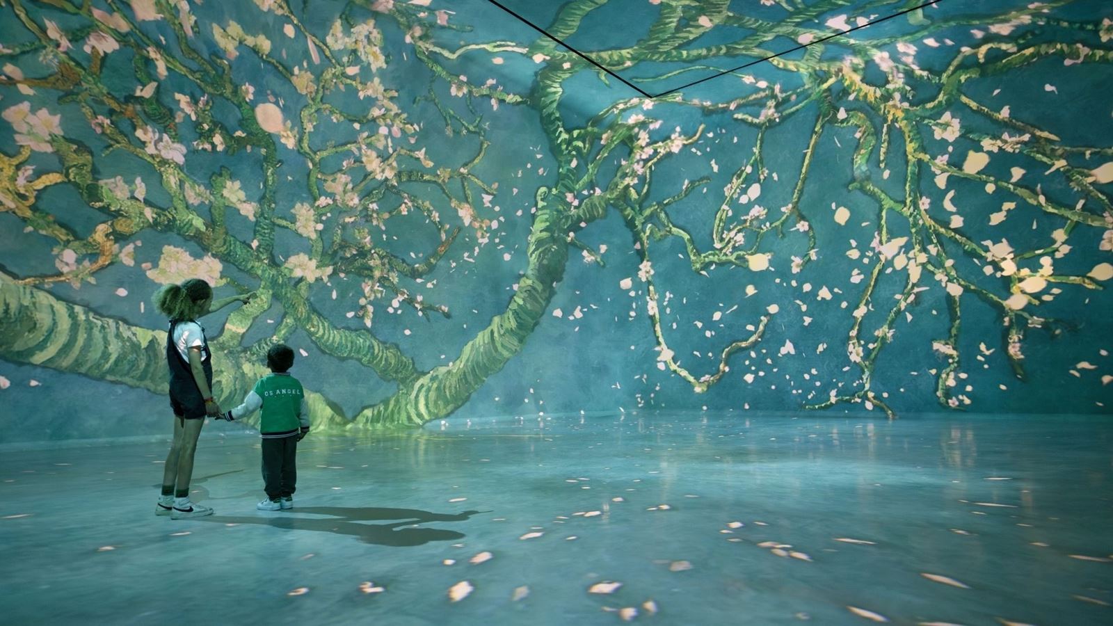 A mother and son in front of a flower paining at FRAMELESS