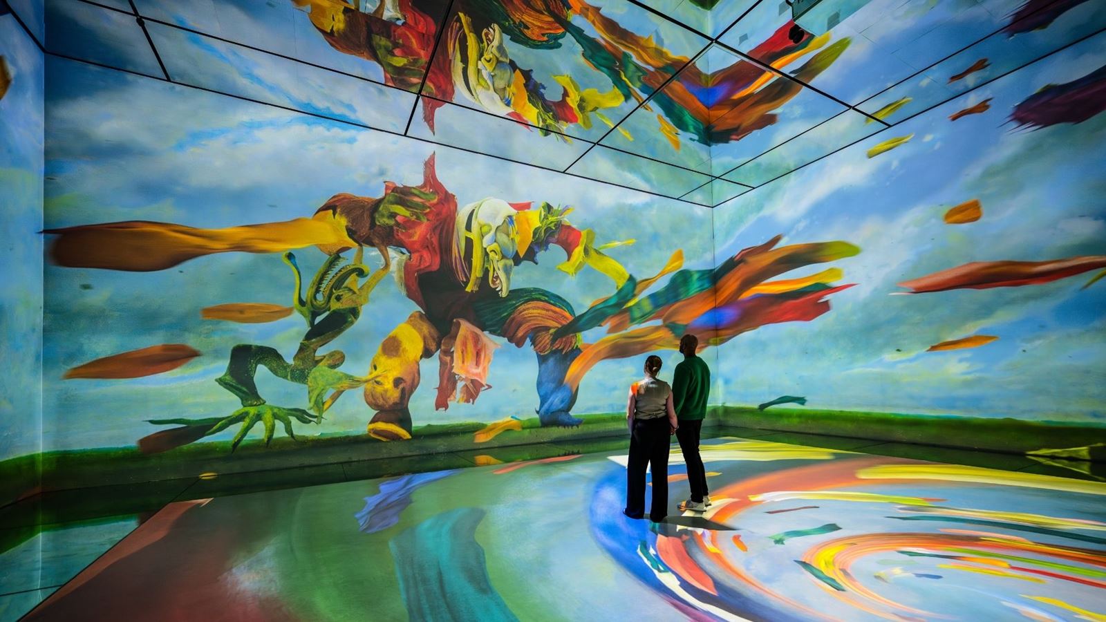 Two people immersed in a vibrant painting at FRAMELESS