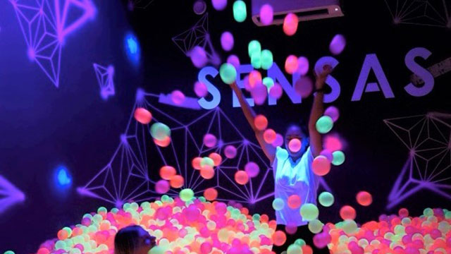 Die farbenfrohe Ballgrube im immersiven multisensorischen Erlebnis SENSAS © SENSAS. Bild mit Genehmigung von SENSAS. Zwei Personen spielen in SENSAS in einem Ballbecken gefüllt mit unterschiedlich farbigen Bällen