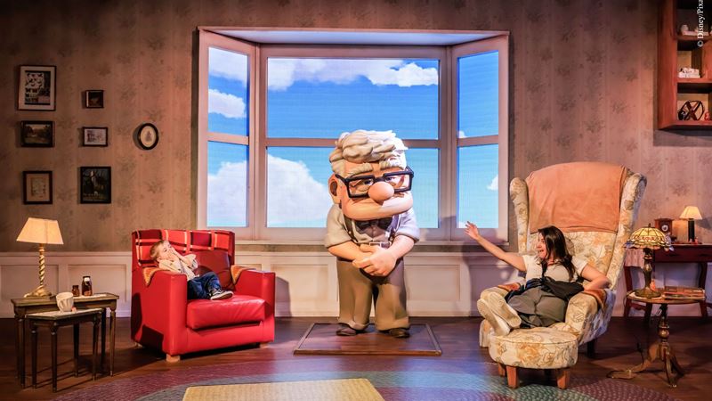 A scene from a Disney and Pixar immersive experience, featuring a life-sized character from Up in a detailed set inspired by the film. Image courtesy of Deacon Communications. Children interact with a life-sized character from Disney and Pixar’s Up inside a recreated living room set.