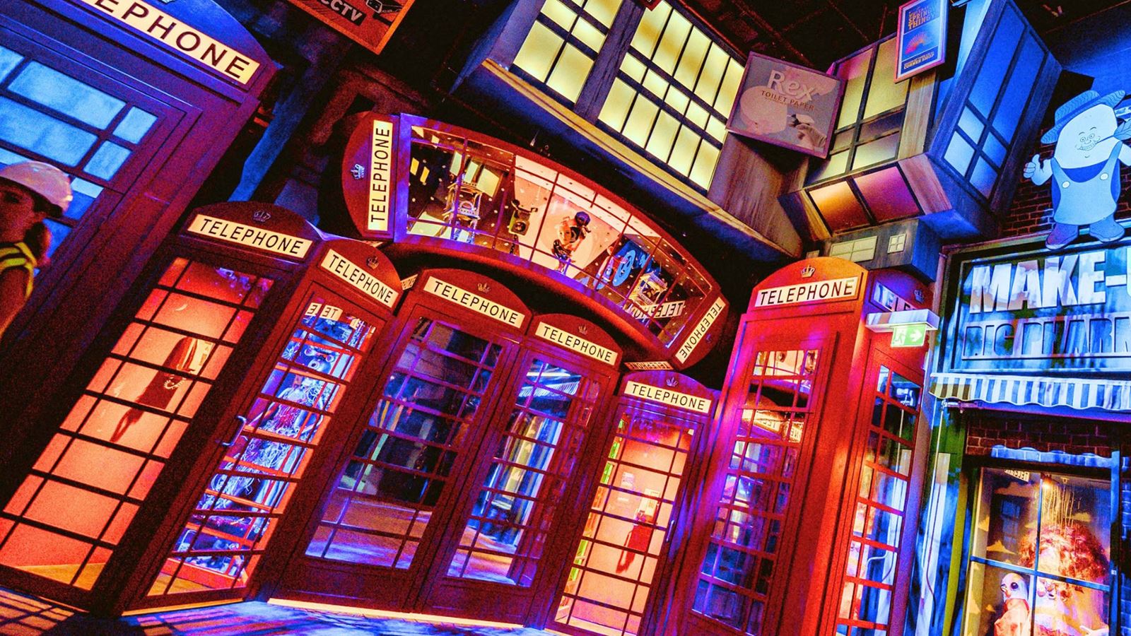 A collection of brightly lit red telephone boxes