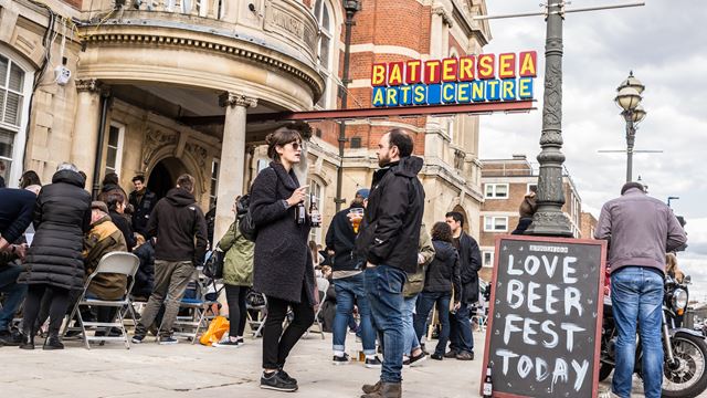 People drinking beer in front of Battersea Arts Centre during the annual craft beer festival.