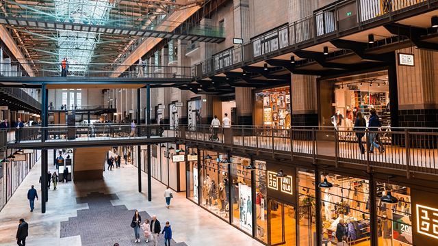 People walking inside Battersea Power Station, which now houses shops and restaurants.