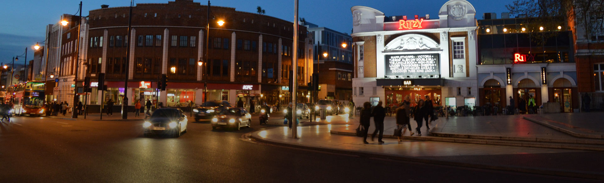 Brixton at night with Ritzy Cinema lit up in the background.