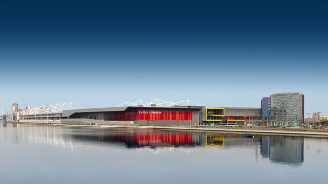 A panoramic view of a modern convention centre with the river Thames in the foreground.