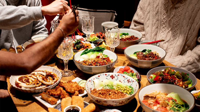 Savour bold and comforting Sichuan flavours at Noodle & Beer in Chinatown, open until 4am on Fridays and Saturdays. Credit: Noodle and Beer. Image courtesy of Noodle and Beer. A group of people sharing a multiple dishes at Noodle & Beer in Chinatown