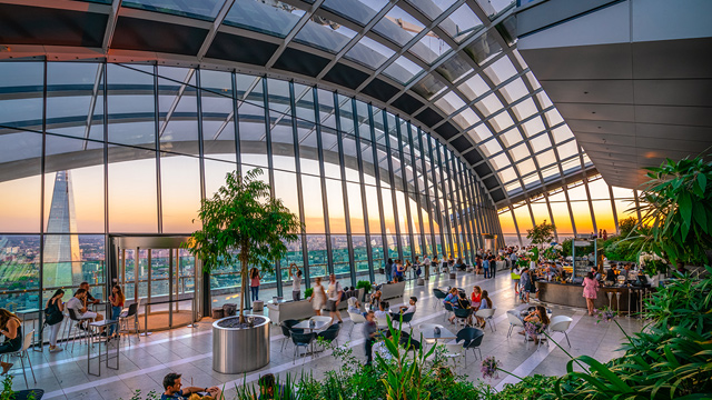 Profitez d'une vue imprenable sur la capitale depuis le Sky Garden de Londres. Image reproduite avec la permission de : Shutterstock. Le Sky Garden de Londres avec des arbres et des baies vitrées surplombant la ville.