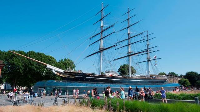 Des gens profitant du soleil à l'extérieur du navire Cutty Sark à Greenwich.