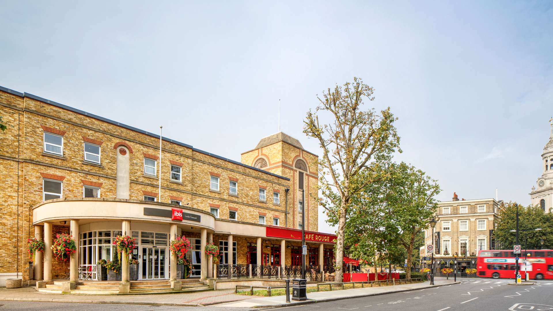 A photo of the exterior of Ibis London Greenwich with a view of Greenwich high street in the background