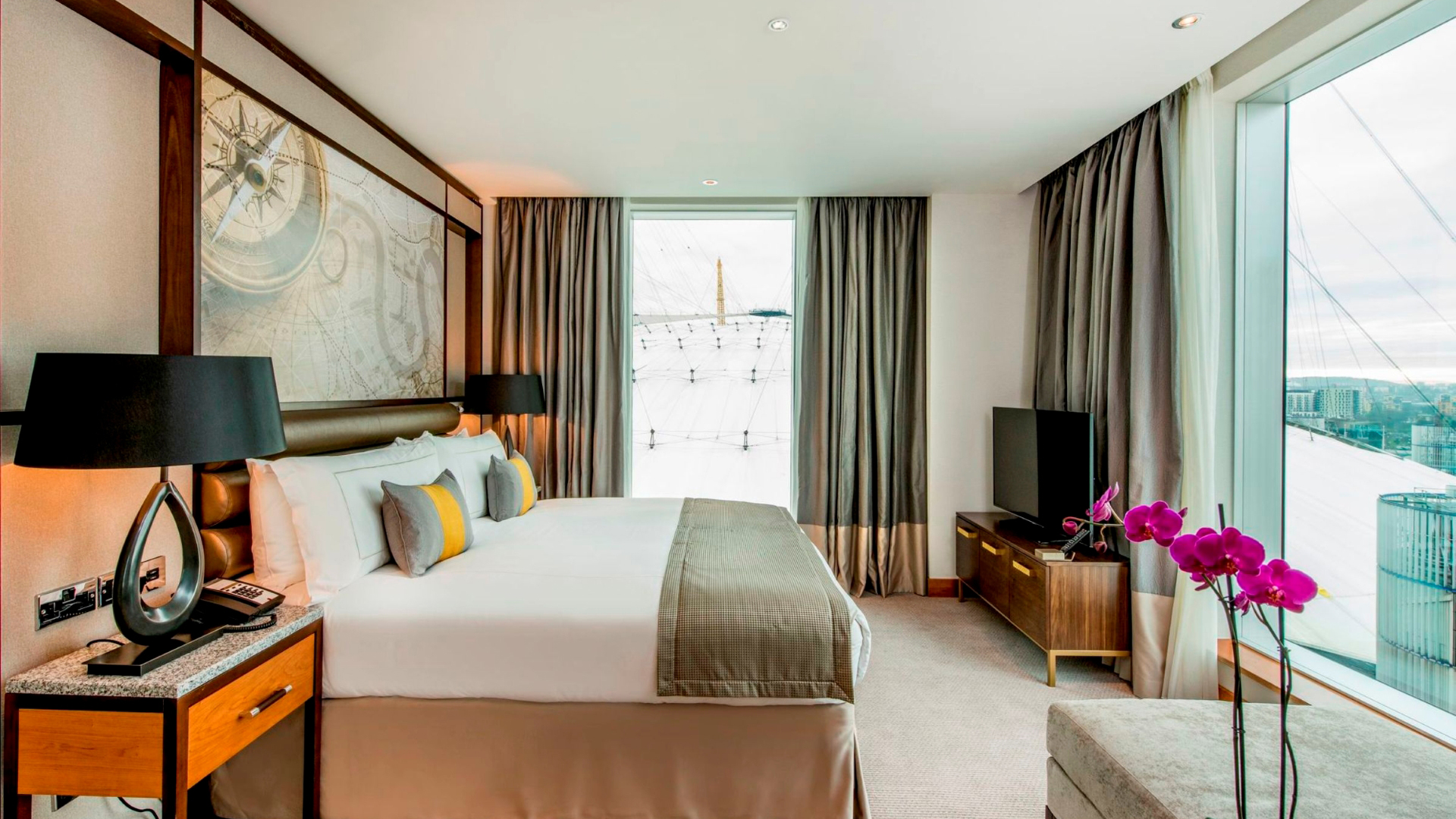 A photo of a spacious double room at the InterContinental London at The O2 with two windows, one overlooking the venue and another onto the river Thames with views of the city