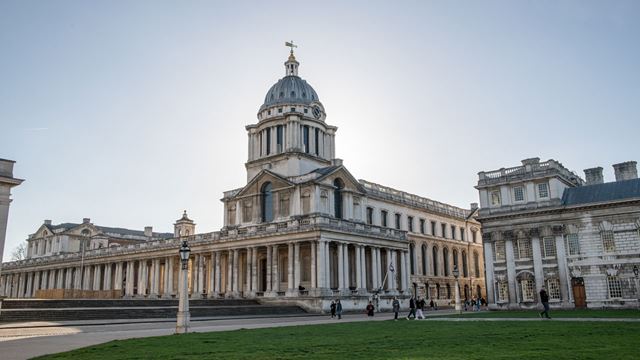 A statue stands in the middle of a path in the grounds of the Old Royal Naval College.