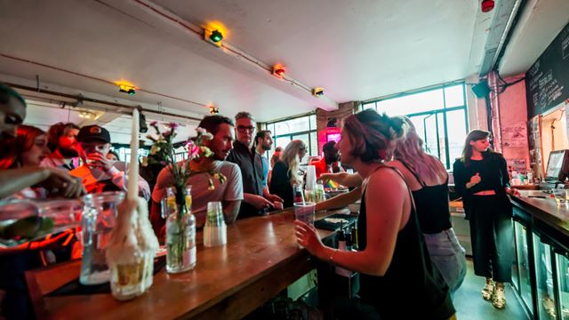 A photo of the Arcola Bar at Arcola Theatre in Dalston with employees behind the bar serving customers
