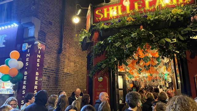 A photo of the Auld Shillelagh pub on Church Street in Stoke Newington decorated with coloured balloons for St Patrick's Day with crowds of people inside and out