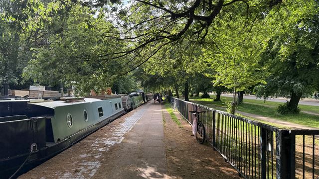 A photo of the canalside path running between Regent's Canal and Victoria Park on a sunny day