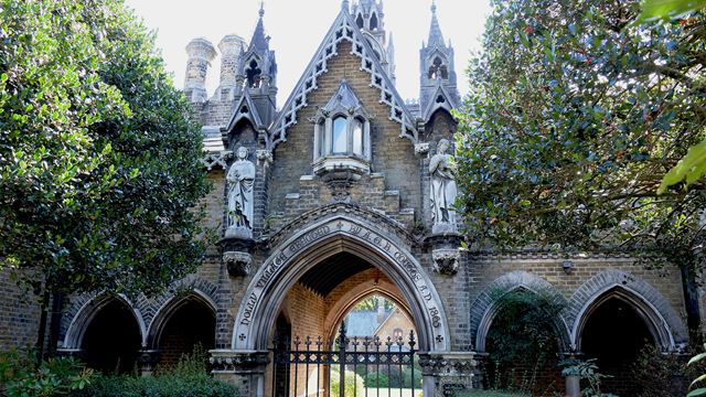 The outside gate of Holly Village in Highgate features intricate Gothic sculptures and impressive architectural details.