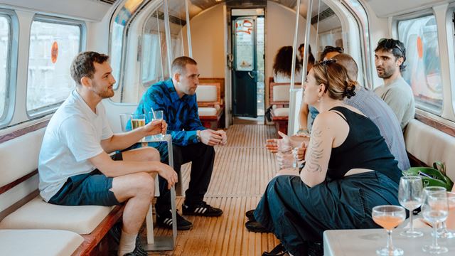 A photo of the Village Underground rooftop with people enjoying drinks inside a repurposed Tube carriage.