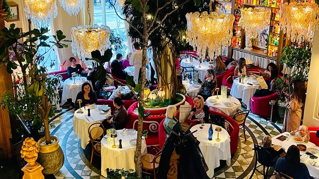 An elegant dining room with big chandeliers and round tables