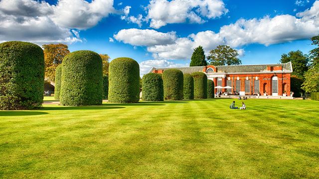 The immaculate lawns and trees in Kensintgon Gardens on a sunny day