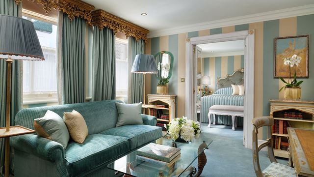 An elegantly decorated blue and white lounge with adjoining bedroom